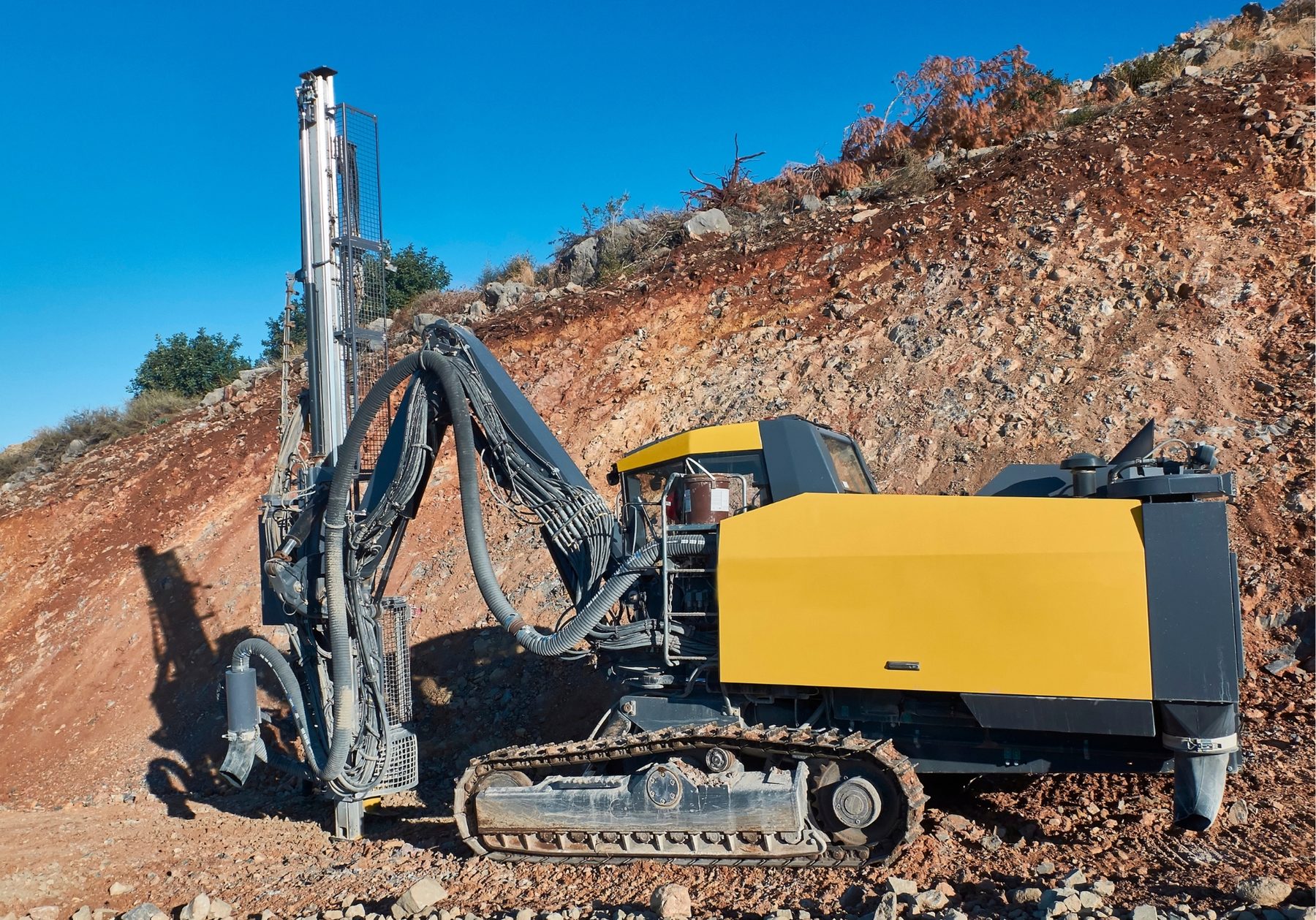 Crawler drill rig working on a rock face, representative of the mining, quarrying and civil drilling fleets MMST supports across East Africa